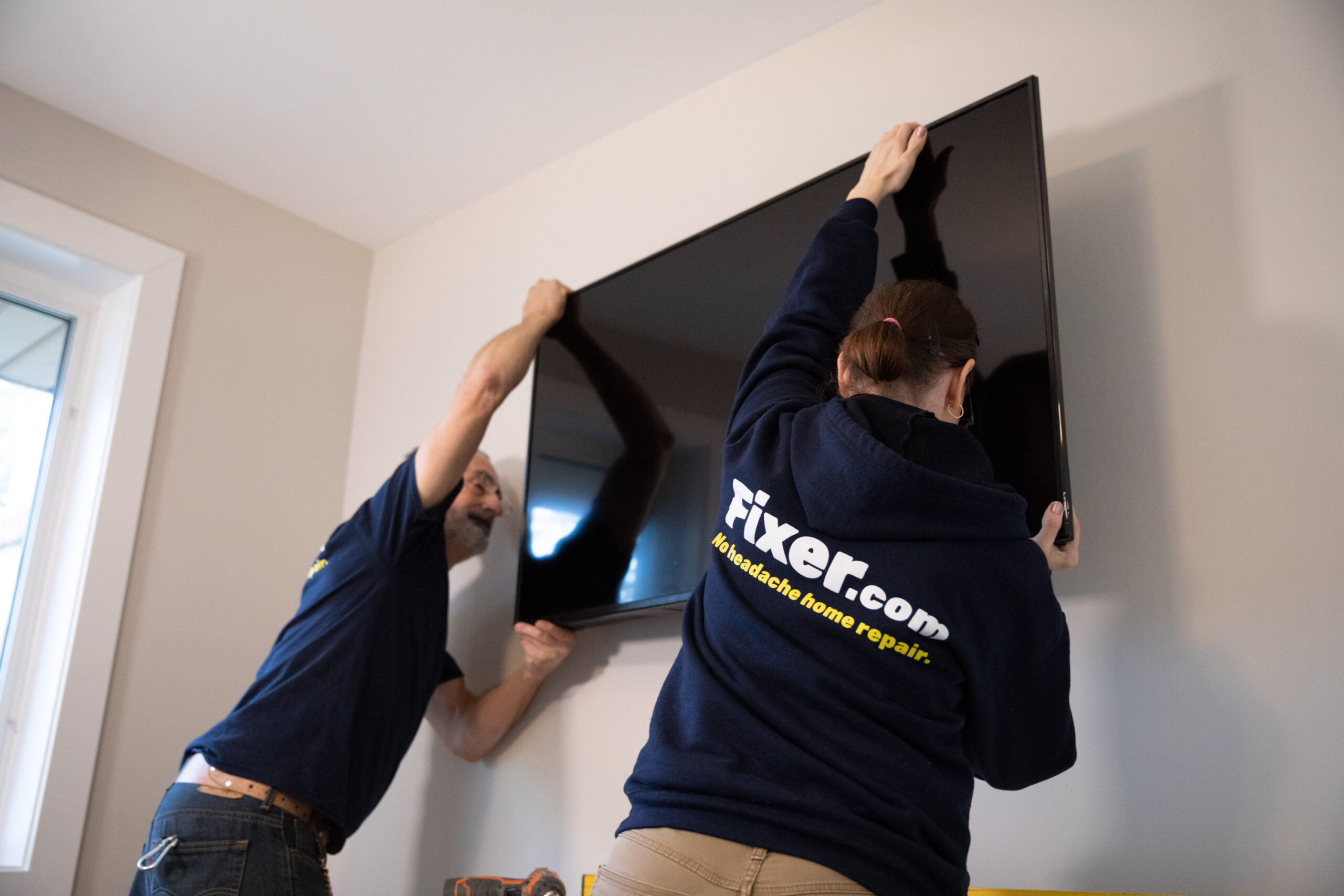 Fixer professionally mounting a television